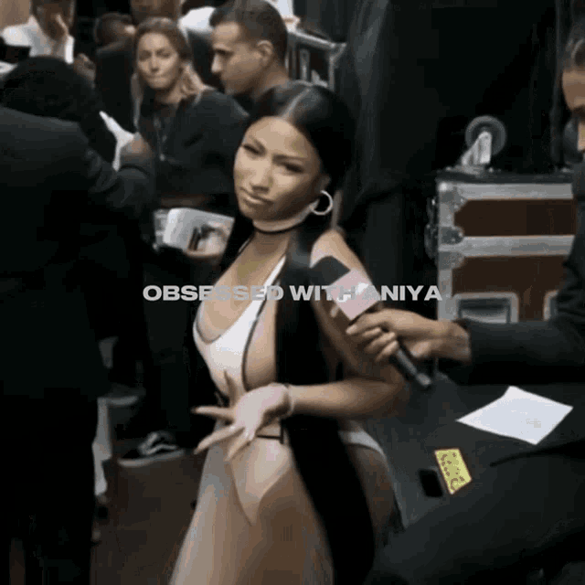 a woman in a white swimsuit is being interviewed by a man with the words " obsessed with nia " written above her