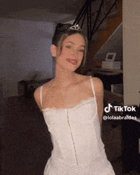 a woman in a white dress with a tiara on her head is on tiktok