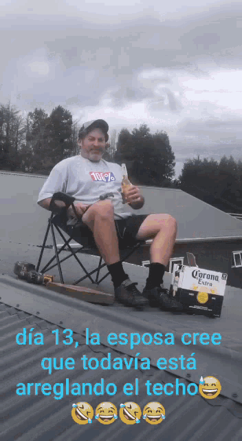 a man sitting on a roof holding a bottle of corona beer