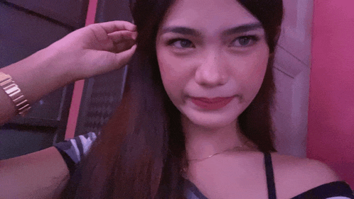 a woman taking a selfie with her hand on her hair