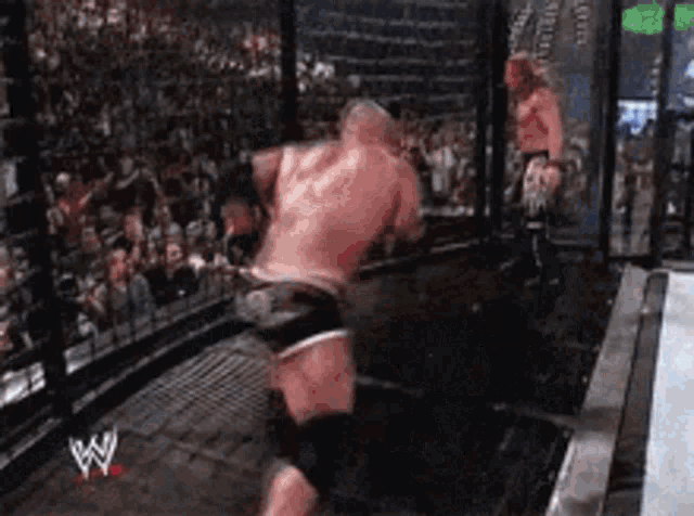 two men are wrestling in a ring with a w logo on the bottom