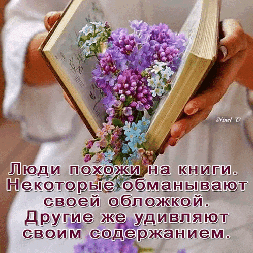 a person holding a book with purple and blue flowers on it