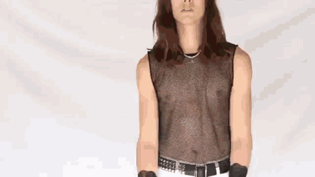 a woman with long hair wearing a suit and a striped shirt is making a funny face .