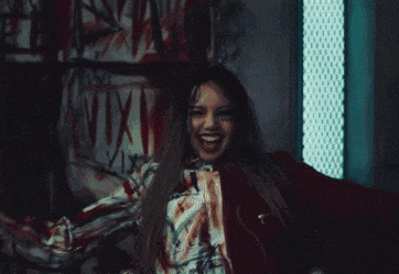a person with blood on their face is standing in front of a sign that says ' nvx ' on it