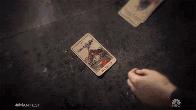 a person holding a tarot card that says sword