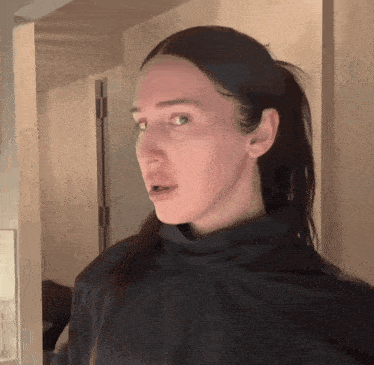 a woman with long hair is wearing a black turtleneck