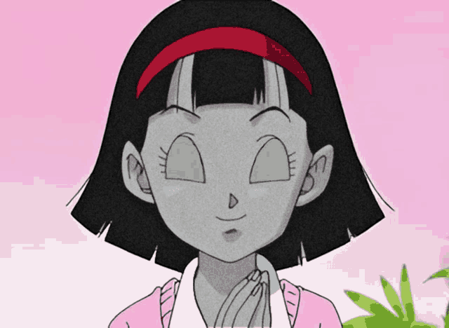 a girl with short black hair and a red headband is smiling