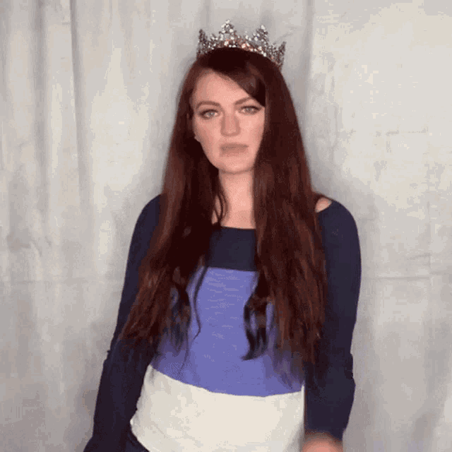 a woman with long red hair is wearing a crown