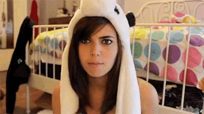 a woman is wearing a panda hat and making a funny face