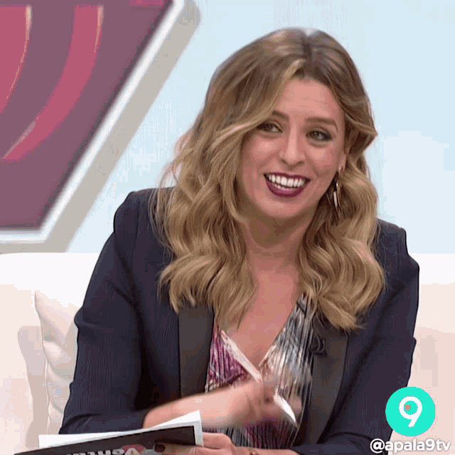 a woman sitting on a couch with the number 9 on the corner