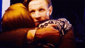 a man and a woman are hugging each other in a pixelated image .
