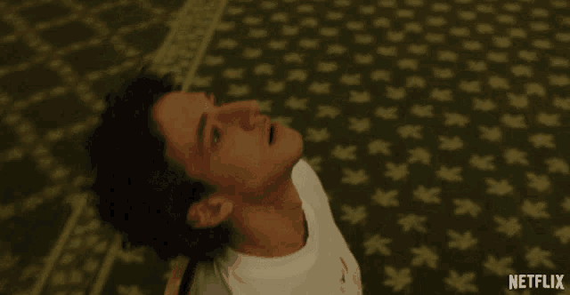 a man laying on a green carpet with netflix written on the bottom