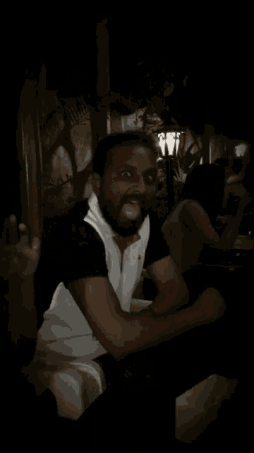 a man with a beard wearing a black and white polo shirt and a red tie