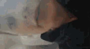 a close up of a woman 's face with smoke coming out of her nose .