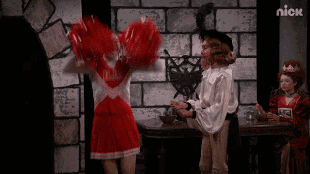 a cheerleader with red pom poms stands next to a boy in a pirate outfit