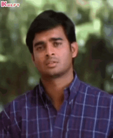a man in a blue plaid shirt is looking at the camera .