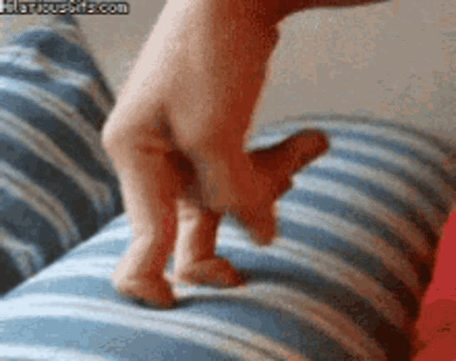 a person 's foot is on a blue and white striped pillow .