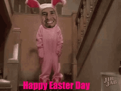 a man in a pink bunny costume is standing on a set of stairs with a happy easter day message .