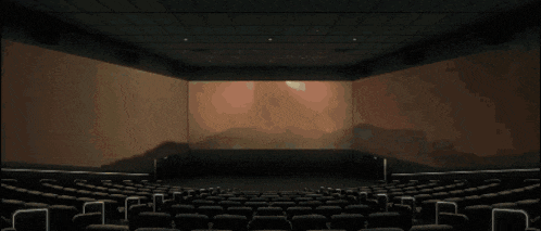 an empty movie theater with a picture of a giant monster on the screen