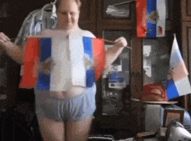 a man in underwear holds a russian flag in his hands