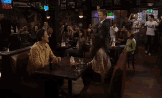 a group of people sitting at tables in a bar