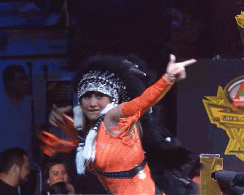 a woman in a costume with a crown on her head is pointing at something