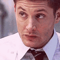 a close up of a man 's face wearing a white shirt and tie .