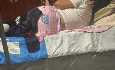 a person laying on a bed with a donut on their shorts