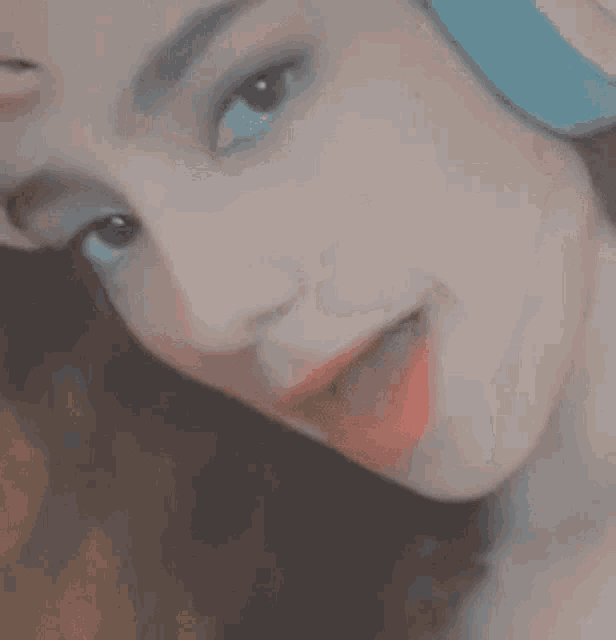 a close up of a woman 's face with a blue hat on .