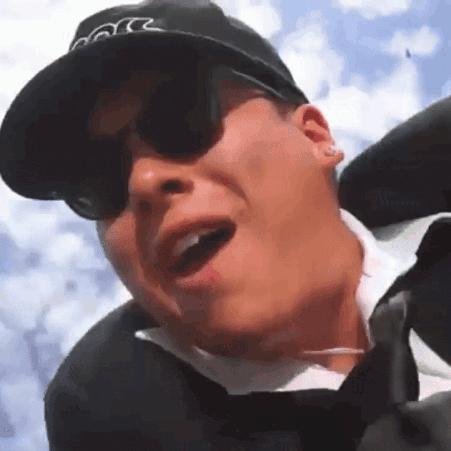a man wearing a hat and sunglasses is making a funny face with his mouth open
