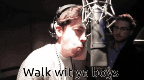 a man wearing headphones stands in front of a microphone with the words walk wit ya boys written below him