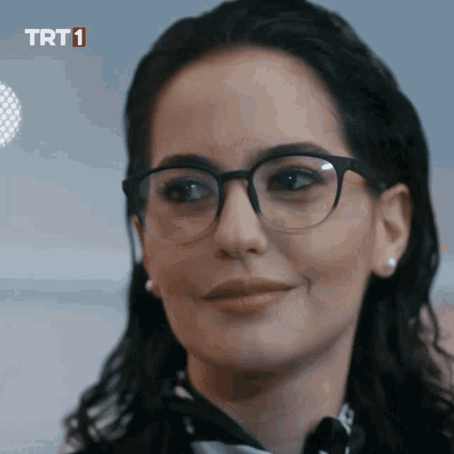 a close up of a woman wearing glasses with trt1 in red