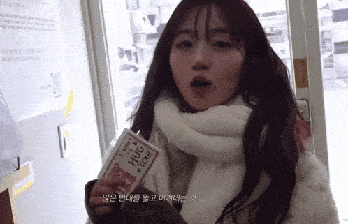 a woman is holding a card that says i love you