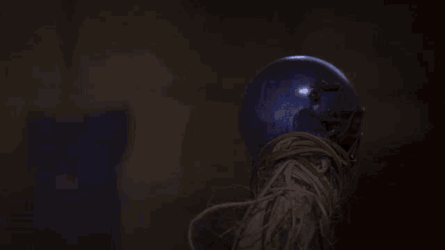a blue light bulb is sitting on a rope in the dark