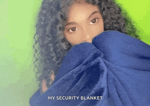 a woman with curly hair is covering her face with a blue blanket with the words my security blanket written on the bottom