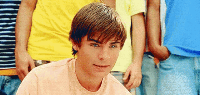 a young man is sitting in front of a group of people .