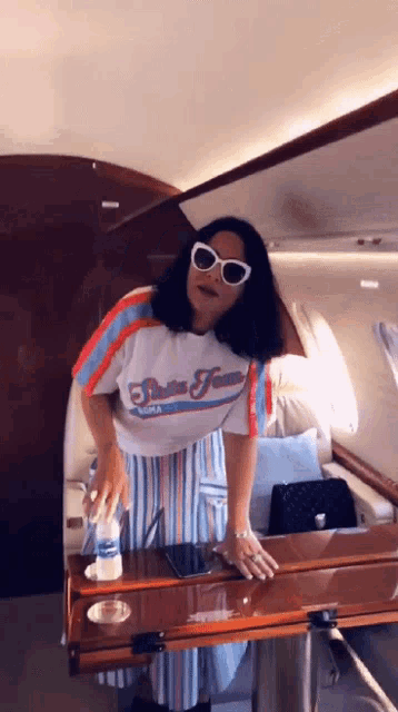 a woman wearing sunglasses and a shirt that says ' rolling stones '