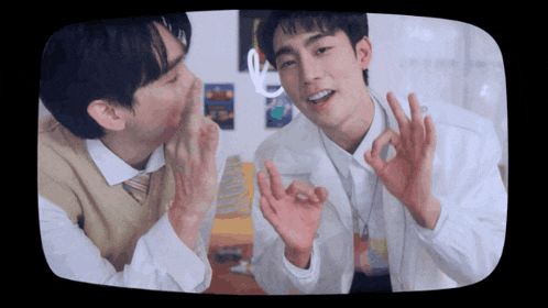 two young men are giving each other a thumbs up sign