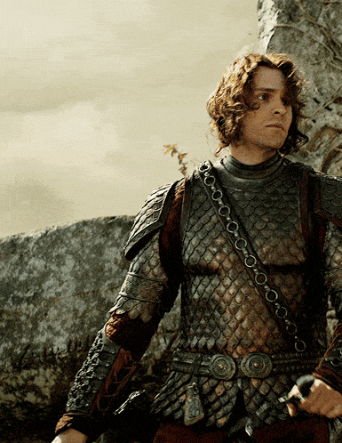 a man in armor is holding a sword in his hand