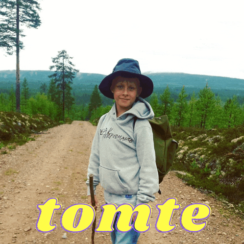a boy with a backpack stands on a dirt road with the word tome written in yellow