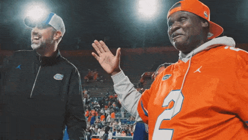a man wearing an orange jersey with the number 2