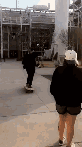 a man is riding a skateboard while a woman walks by