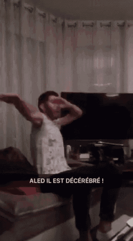 a man is sitting on a couch with his arms outstretched and the words aled il est decerebre written below him