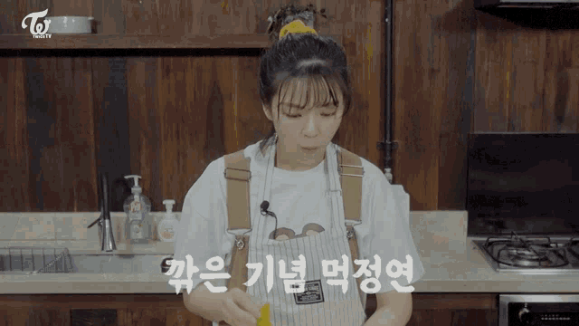 a woman in an apron is cooking in a kitchen with a twice logo on the bottom