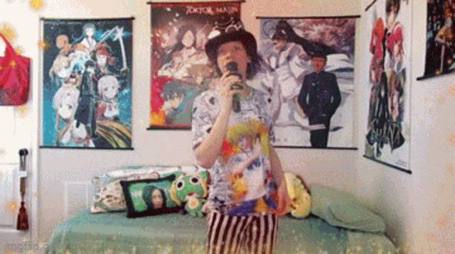 a man singing into a microphone in a bedroom with posters on the wall including one that says tokyo manji