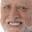 a close up of an elderly man 's face with a beard smiling .