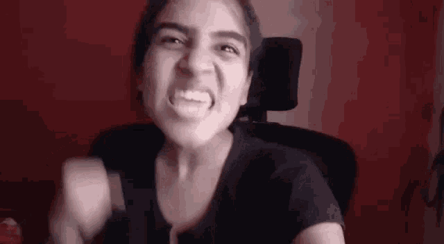 a young woman is making a funny face while sitting in a chair .