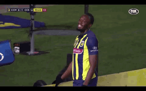 a soccer player wearing a yellow and blue jersey that says masterfoods