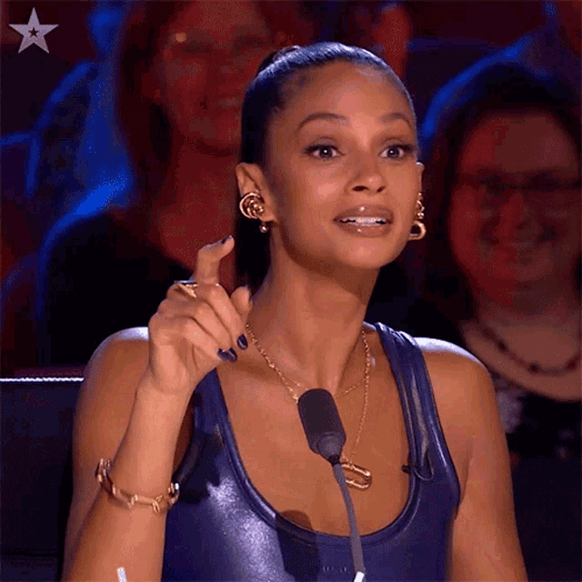 a woman sitting in front of a microphone with a star in the corner