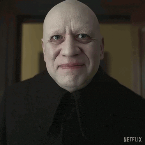 a bald man in a black coat with netflix on the bottom